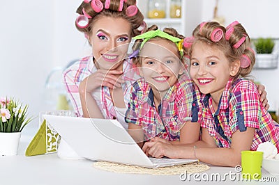 Girls and mother in hair curlers with laptop Stock Photo