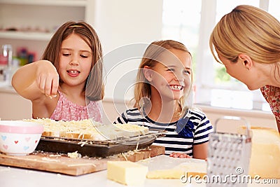 Girls With Mother Making Cheese On Toast Stock Photo