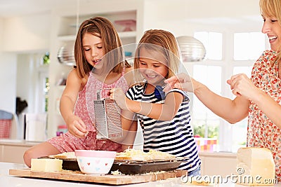 Girls With Mother Making Cheese On Toast Stock Photo