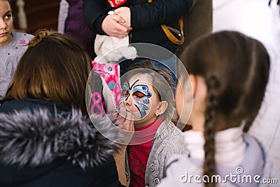 Girls painting faces to children a master class at the opening of a children`s center in Cherkasy, Ukraine, March 23, 2018 Editorial Stock Photo