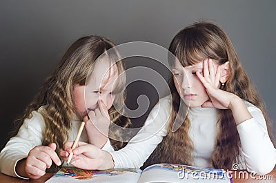 Girls read and one picks his nose Stock Photo