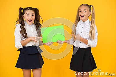 Girls school uniform hold poster. Back to school concept. Schoolgirls show poster. Social poster copy space Stock Photo