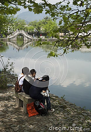 Girls sitting on a bench in Hongcun (China). Editorial Stock Photo