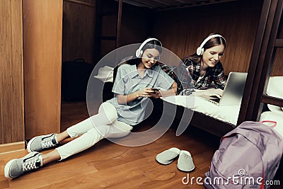 Girls sitting and lie looking at laptop and phone Stock Photo