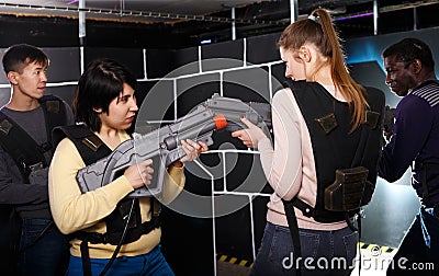 girls standing face to face with laser guns on lasertag gaming arena Stock Photo