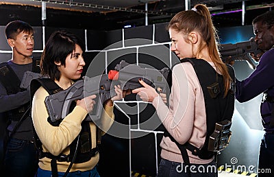 girls standing face to face with laser guns on lasertag gaming arena Stock Photo