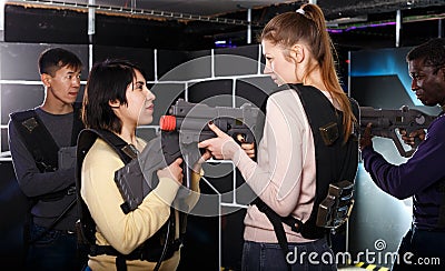girls standing face to face with laser guns on lasertag gaming arena Stock Photo