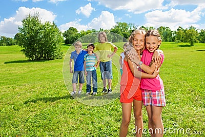 Girls standing in the park hugging Stock Photo