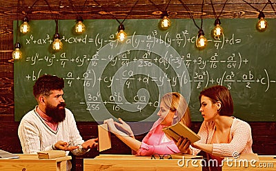 Girls students and bearded teacher, lecturer, professor. College and education concept. Students, young scientists Stock Photo