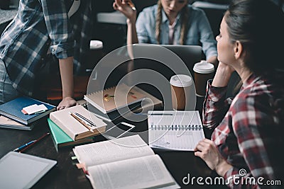 Girls students drinking coffee and studying together at table Stock Photo