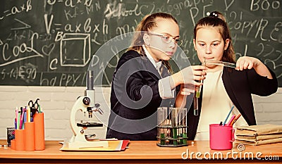 Girls study chemistry. Make studying chemistry interesting. Educational experiment concept. Microscope and test tubes on Stock Photo