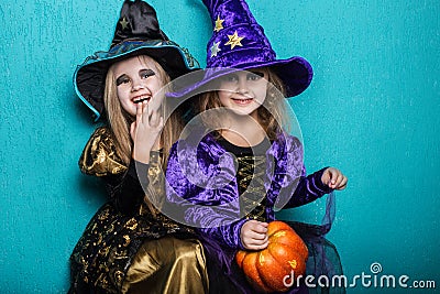 Girls in a suit of a witch. Halloween. Fairy. Tale. Studio portrait on blue background Stock Photo