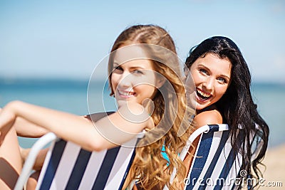 Girls sunbathing on the beach chairs Stock Photo