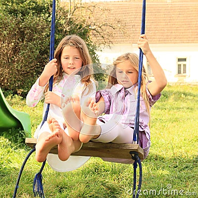 Girls swinging on swing Stock Photo