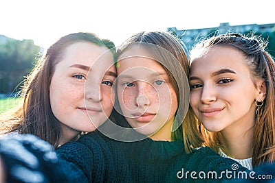 Girls teenage schoolgirls take pictures on a phone, selfie picture, happy smiling, emotions of joy, delight and fun Stock Photo