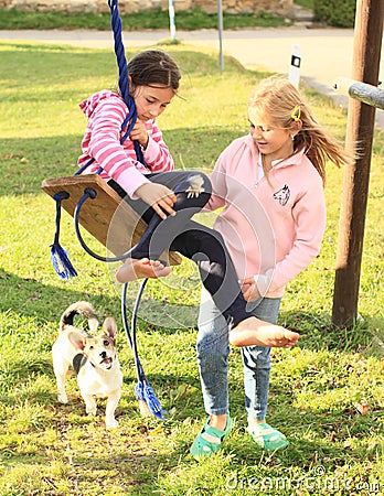 Girls twisting on swing Stock Photo