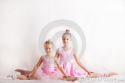 Girls - young ballerinas in pink dresses on a light background Stock Photo