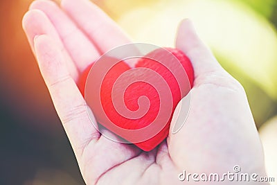 Give Love Man holding small red Heart in hands for love Valentines day Stock Photo