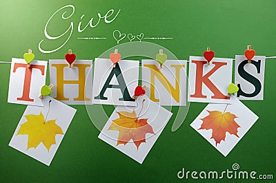 Give Thanks message hanging from pegs on a line for Thanksgiving greeting with leaves Stock Photo
