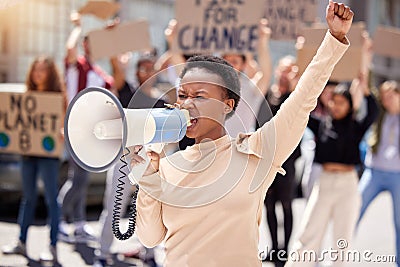 Give us what we want. a young woman shouting through a loudhailer at a protest. Stock Photo