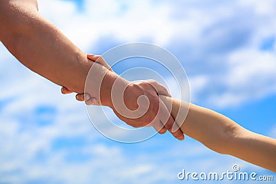 Giving a helping hand. Hands of man and woman on blue sky background. Lending a helping hand. Hands of man and woman Stock Photo