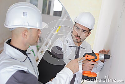 Giving instruction to builder to drill wall Stock Photo