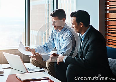 Giving legal advice online will double your money. two businessmen having a discussion while sitting by a laptop. Stock Photo