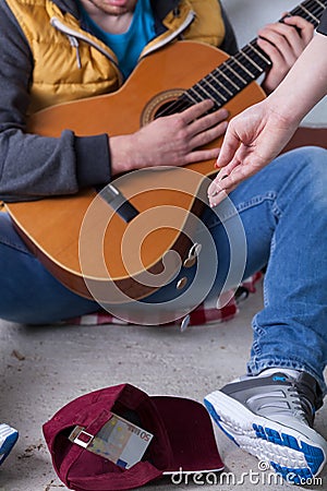 Giving money to street guitarist Stock Photo