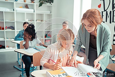 Attentive teacher showing a pupil needful exercise. Stock Photo