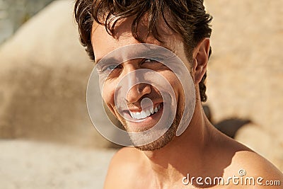Giving you a relaxed smile. Cropped portrait of a handsome man smiling while at the beach. Stock Photo