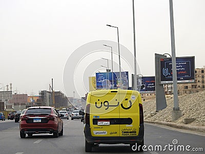 Noon online shopping delivery yellow van to deliver a package, Arabic Translation (Noon.com express for Editorial Stock Photo