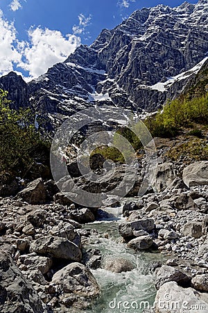 Glacial stream in alpine valley rugged terrain Stock Photo