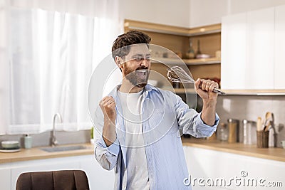 Glad adult caucasian male superstar in white t-shirt sings song at imaginary microphone whisk Stock Photo