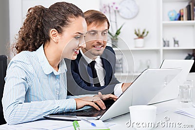 Glad business female assistant wearing formalwear using laptop Stock Photo