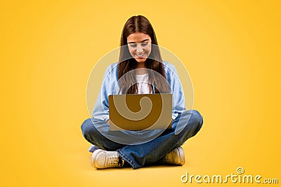 Glad caucasian teenager student lady use computer, typing and sit on floor Stock Photo