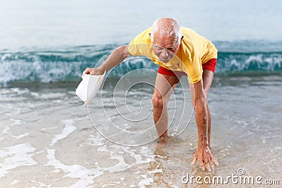 Glad elderly man touches the water temperature Stock Photo