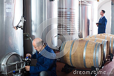 Glad man machinery operator working in winery Stock Photo