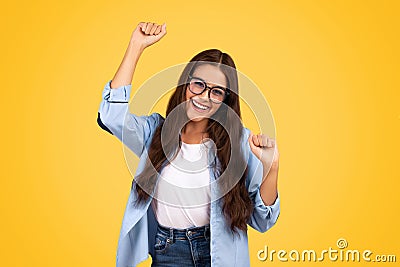 Glad shocked european teen woman in glasses exuberant celebrates win, rise fists Stock Photo