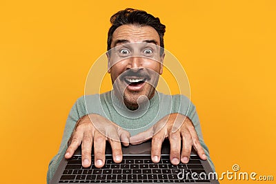 Glad shocked funny senior european man typing on keyboard laptop, with open mouth Stock Photo