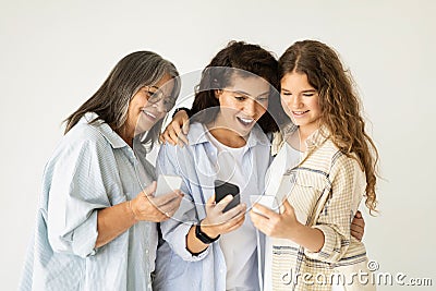 Glad shocked millennial, senior women and teen girl enjoy chat on phone, have fun Stock Photo