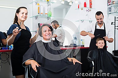 Glad woman hairdresser working with woman Stock Photo