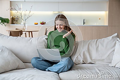 Glad woman looking at notebook screen, having video online conversation with friends, relatives Stock Photo