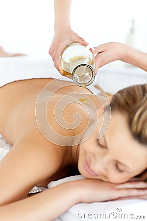 Glad young woman enjoying a back massage with oil Stock Photo