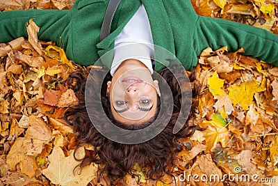 Gladsome woman lying in autumn leaves stock photo Stock Photo