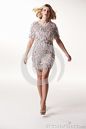 Glamorous blonde woman walking towards camera, full length Stock Photo