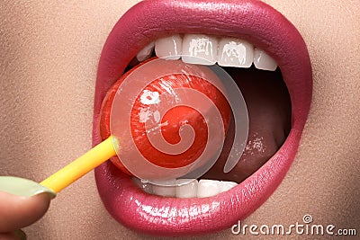 Glamour macro shoot with woman's lips with a sweet bonbon lollipop Stock Photo