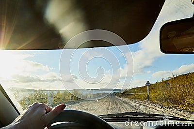 Glare on the car front window and view on nature landscape with road, water and grass Stock Photo