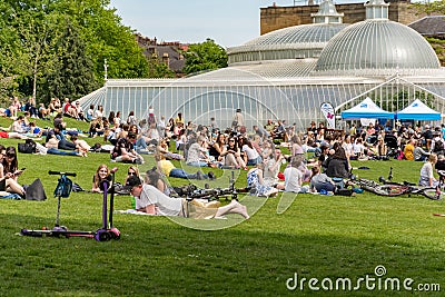 Glasgow, Scotland - May 19, 2018: View of a park in front of the botanic gardens in Glasgow, where people enjoy the late spring Editorial Stock Photo