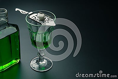 A glass of absinthe and a stainless steel slotted spoon Stock Photo