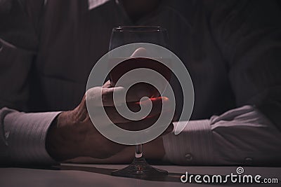 Glass with alcohol in hand close up Stock Photo